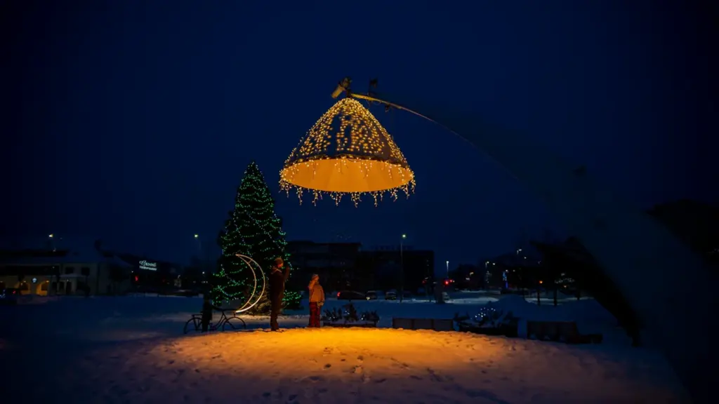 Lumisel Rakvere keskväljakul säravad dekoratiivsed tuled ja jõulupuu pimedal talveõhtul.
